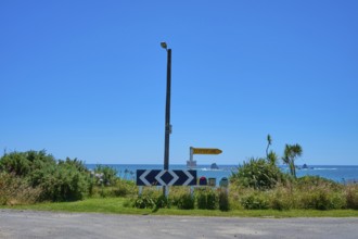View of a coastline with road signs and blue sky, Cape Foulwind, West Coast, South Island, New