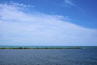 Sweeping view of the calm sea under a partly cloudy blue sky, Mana Bay, Patea, Taranaki, North