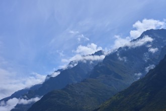 Mountain peak in the foreground with white clouds in the sky, Drift Bay, Lake Wakatipu,