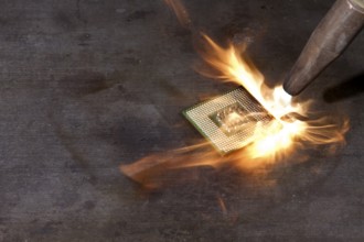 CPU and welding torch with big flame on metallic ground