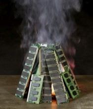Pile of random access memory sticks and flame in front of dark back