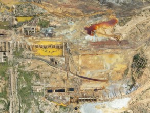 Old mining site and deep orange-red hues in the water of a pool in the mineral-rich area of the Rio