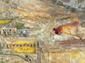 Old mining site and deep orange-red hues in the water of a pool in the mineral-rich area of the Rio