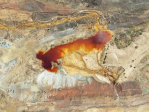 Old mining site and deep orange-red hues in the water of a pool in the mineral-rich area of the Rio