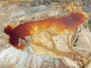 Deep orange-red hues in the water of a pool in the mineral-rich area of the Rio Tinto mines. The