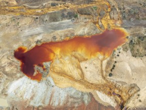 Deep orange-red hues in the water of a pool in the mineral-rich area of the Rio Tinto mines. The