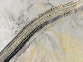 Causeway at a waste pond in the mineral-rich area of the Rio Tinto mines. Aerial view. Drone shot.