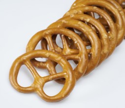 Some lye pretzels in a row in light back