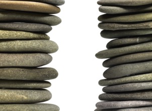 Low angle view of two flat pebble stone stacks in light back