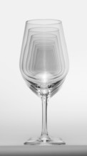Some clean and empty wine glasses standing in a row in light grey back