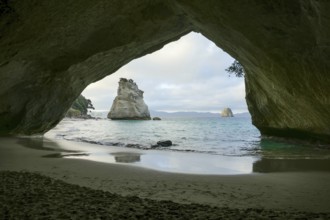 Te Hoho Rock seen through a rock arch at a coastal area named Cathedral Cove in the southern part