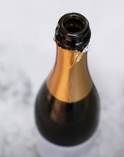 Open champagne bottle seen from above in light ambiance
