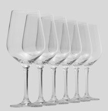 Some clean and empty wine glasses standing in a row in light grey back