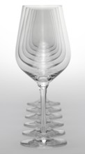 Some clean and empty wine glasses standing in a row in light grey back