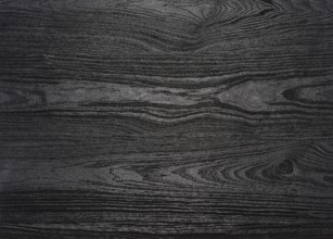 A full frame black wood grain surface