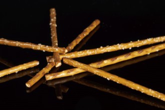 Closeup of some salt sticks on dark striped glossy ground