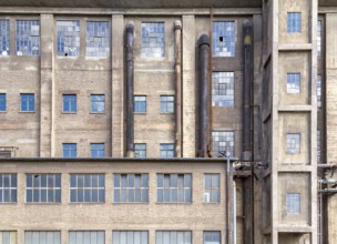 Weathered rundown industrial factory facade with lots of windows