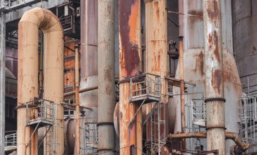 Weathered rusty industrial scenery with old corroded steel girders and metal tubes