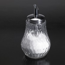 Studio photography of a sugar sprinkler made of glass and metal in dark reflective back