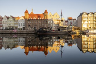 Waterfront promenade with reflection at sunrise in the Old Town, pirate ship, excursion boat,