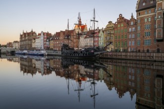 Waterfront promenade with reflection at sunrise in the Old Town, pirate ship, excursion boat,