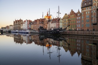 Waterfront promenade with reflection at sunrise in the Old Town, pirate ship, excursion boat,