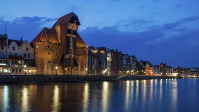 Illuminated waterfront promenade at sunset in the Old Town, Brama Zuraw crane gate, Motlawa River,