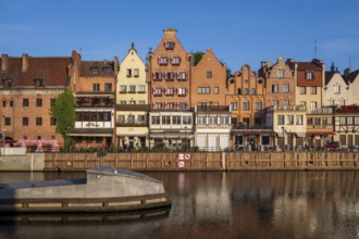 Waterfront promenade with reflection at sunrise in the Old Town, Motlawa River, Gdansk, Poland