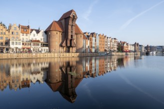 Waterfront promenade with reflection at sunrise in the Old Town, Motlawa River, Gdansk, Poland