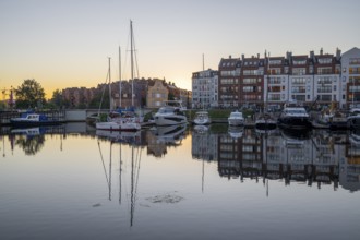 Waterfront promenade with reflection at sunrise in the old town, Motlawa river, boat harbour,