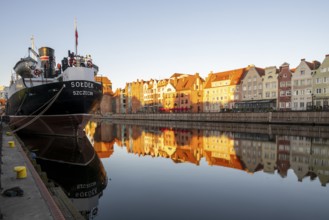 Waterfront promenade with reflection at sunrise in the Old Town, museum ship, Motlawa River,