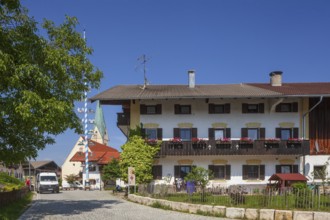 Parish Church of the Assumption of the Virgin Mary with maypole and old houses on the village