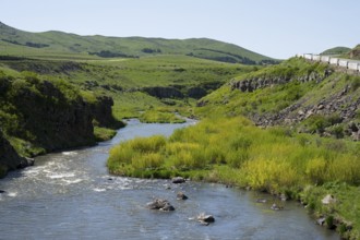 A river runs along green meadows and hills with a road on the right, Achuryan River, Akhuryan, near