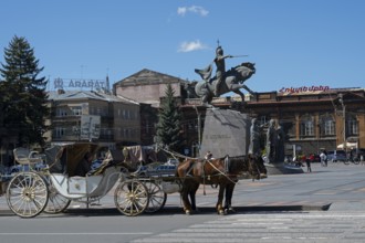 A decorative carriage with horses in front of a historical building with a statue, carriage in