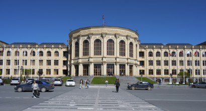 A large town hall with a classical façade, people and cars under a clear sky, Gyumri, Gyumri,