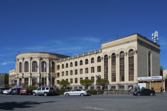 Large historic building in the city centre under a blue sky with parked cars, Gyumri, Gyumri,