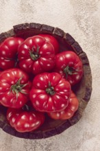 Pink tomatoes, in a rustic wooden bowl, close-up, no people