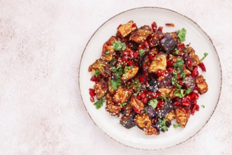 Fried eggplant, Chinese style, in sweet and sour sauce, with pepper and sesame seeds. on a white