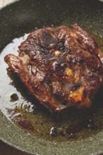Fried steak, veal neck on the bone, cooking meat in a frying pan, top view, no people