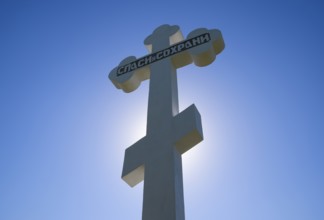 Orthodox cross against the blue sky and the sun. Krasnodar, Russia