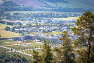View of the residential area at Ölste with industrial buildings and trees in the foreground, Jena,