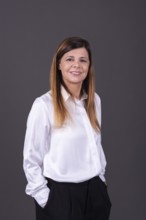 Elegant senior businesswoman smiling with her hands in her pockets