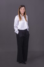 Elegant senior businesswoman smiling with her hands in her pockets