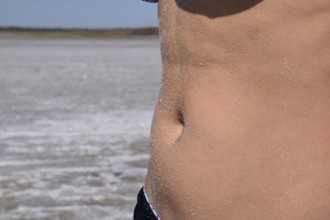 Salt on the girl's stomach. Taman, Krasnodar Krai, Russia