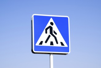 A pedestrian crossing sign. Sign on a blue sky background. Krasnodar, Russia