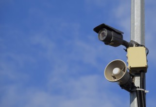 CCTV camera and loudspeaker alarm on a pole against a blue sky. Taman, Krasnodar Krai, Russia