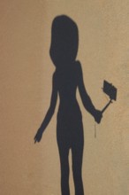 Shadow of a girl with a selfie stick on the beach. Golubitskaya, Russia