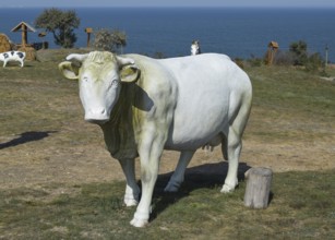 Dummy cow. white toy cow with a bell. Taman, Krasnodar Krai, Russia