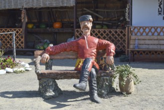 Statue in Cossack fur hat sitting on a bench with a cat. Taman, Krasnodar Krai, Russia