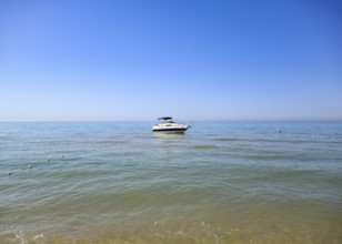 A small boat yacht in the sea near the shore. Taman, Krasnodar Krai, Russia